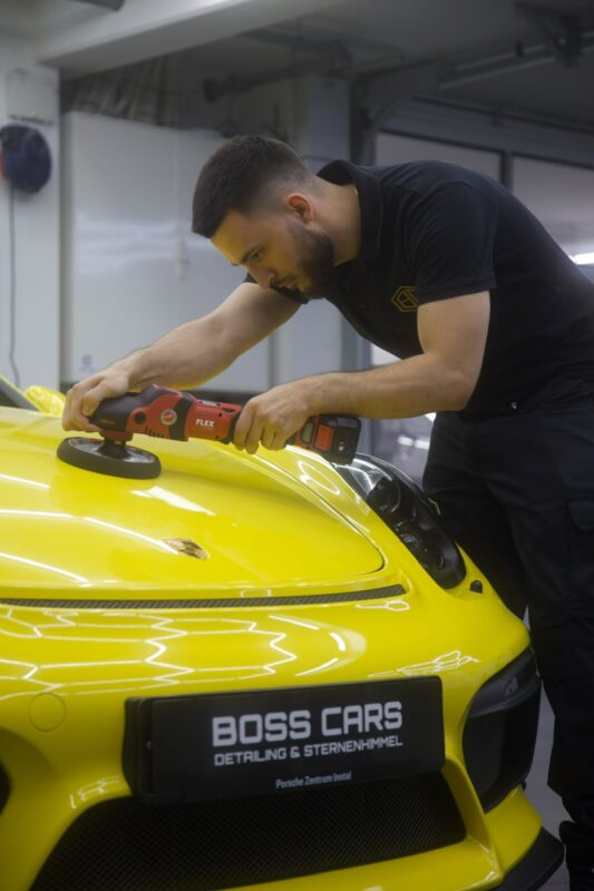 Maschinenpolitur an einem gelben Porsche